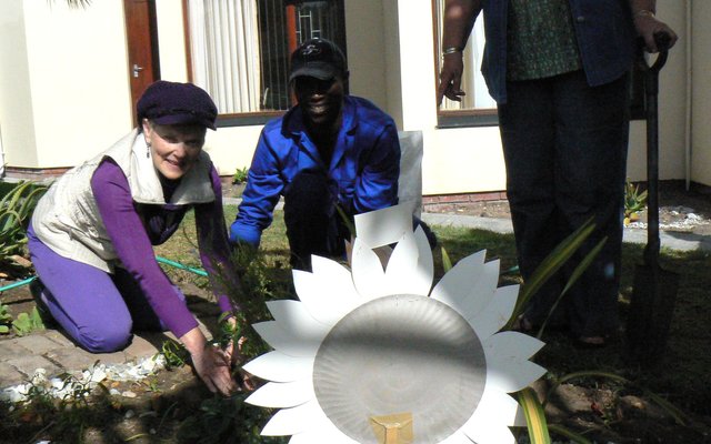 Anita Botha, wie se gesondheid intussen redelik herstel het, plant hier saam met Thando, HaS se regterhand tuinier  